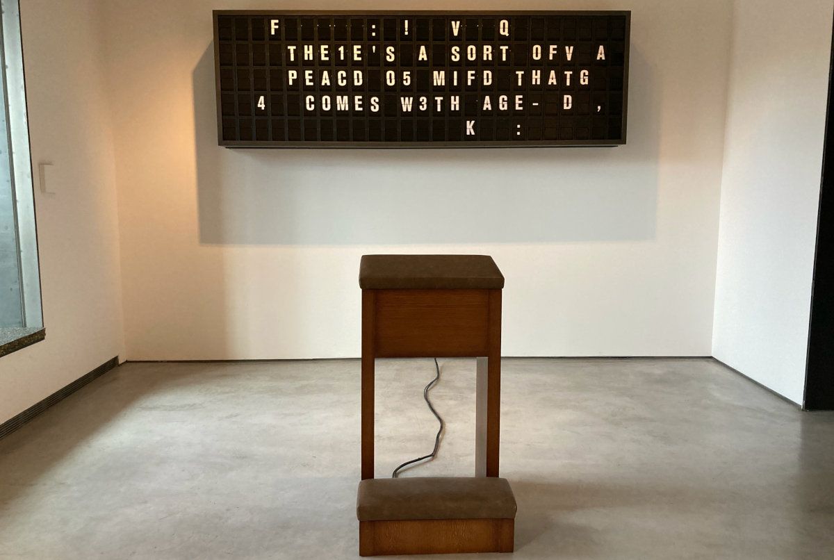 art installation with a mechanical display and a degraded message written on it